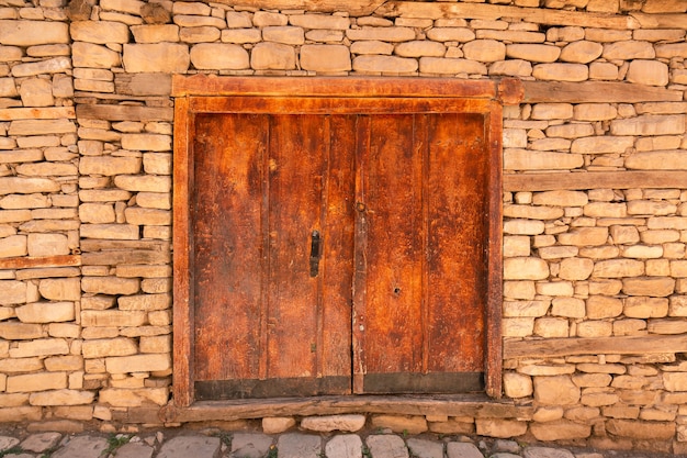 Old wooden ancient door in the stone wall a street in a historical town