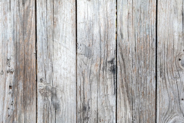 Old wooden background with weathered boards and rusty nails. Shabby old fence