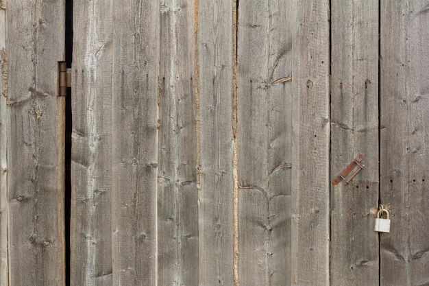 La vecchia porta della stalla in legno è chiusa con un lucchetto