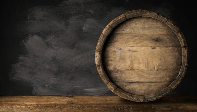 Photo old wooden beer barrel on the dark background.