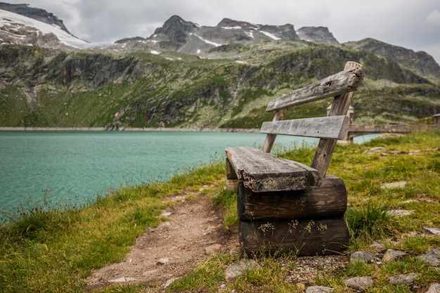 Old wooden bench at a lake in Alps