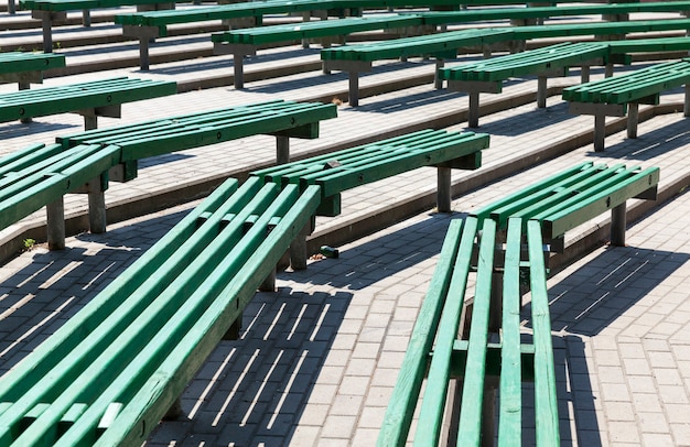 Old wooden benches of green color, old benches located in a summer amphitheater without a roof