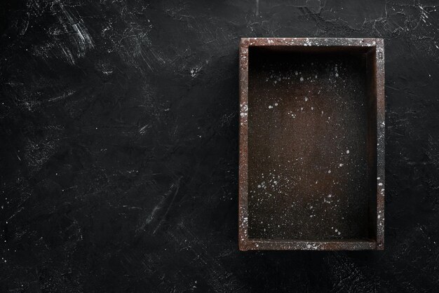 Old wooden black box On a black stone background Top view Free copy space