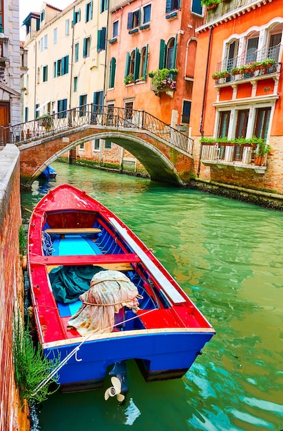 Old wooden boat on canal in Venice, Italy