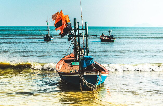 ビーチアンダマン海、タイの古い木製のボート。美しいビーチの暖かい砂と夏の海の風景。夏の壁紙の背景