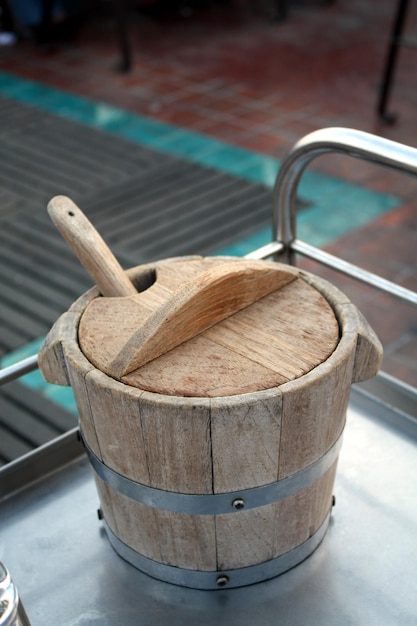 Old wooden bucket for ice on the stainless steel table in the restaurant Selective focus
