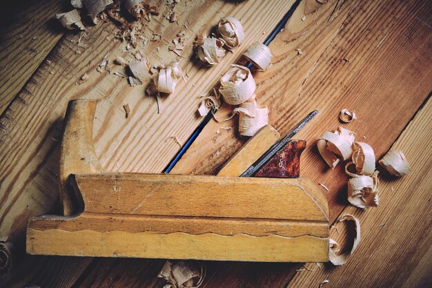 Old wooden carpenters tool plane on a wooden background