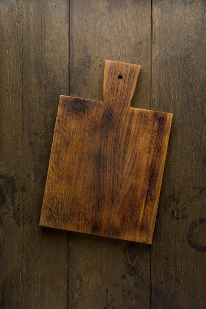 Old wooden chopping board food background overhead vertical dark plank