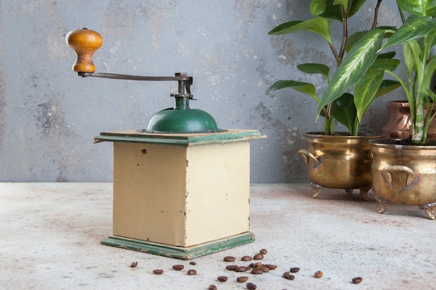 Old wooden coffee grinder on concrete background. 