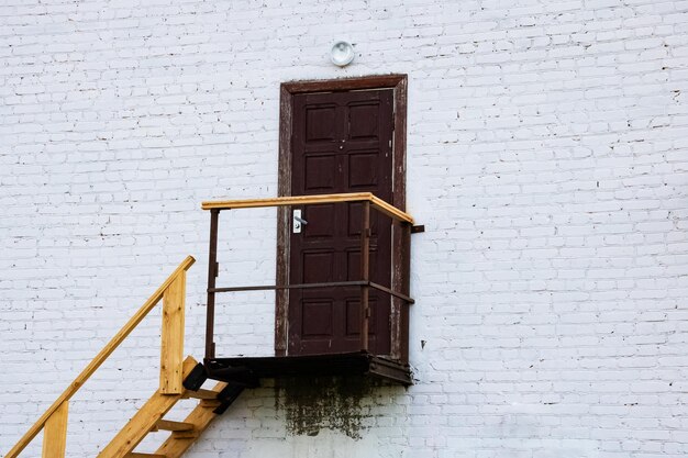 Old wooden door and steps on a brick wall