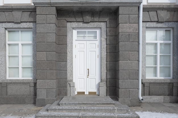 An old wooden door and windows in a granite wall White door and windows in granite masonry Painte