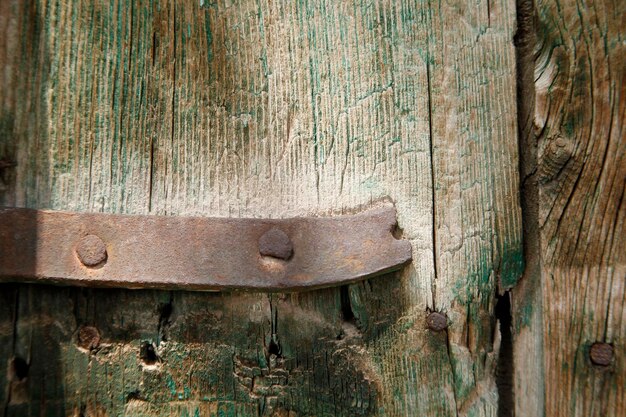 Old wooden door with a rusty piece of iron