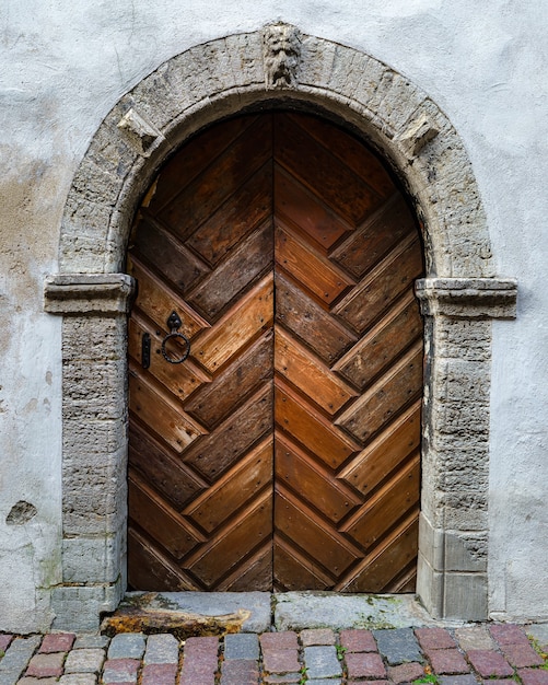 Old wooden door with stone arch in medieval building.