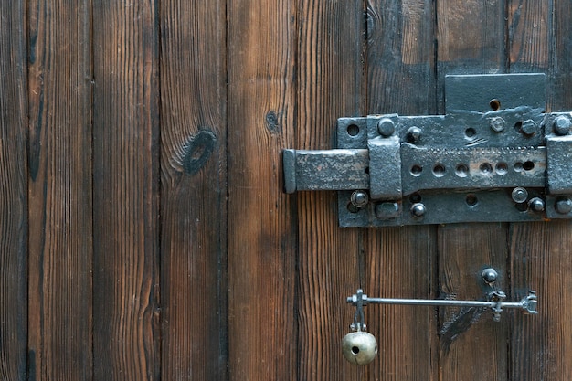 Old wooden doors A big old iron lock An ancient mechanism for locking doors