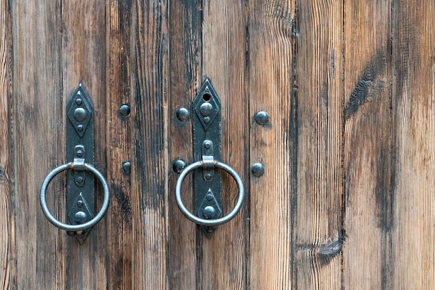 Old wooden doors Iron rings on the gate Decoration elements of buildings vintage iron door handles knockers and gong handle