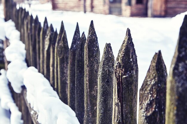 Photo old wooden fence in the countryside winter snow selective focus toning