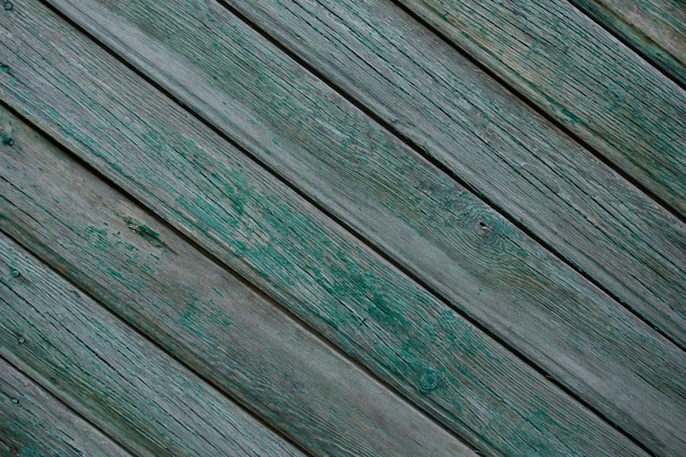 old wooden fence painted with green paint cracked from time