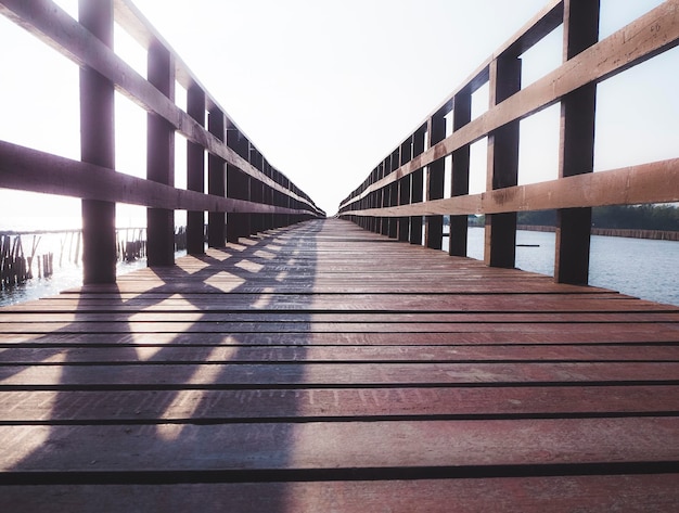 Old Wooden Foot Bridge with handrails over the sea moving on concept idea