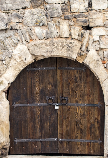 Old Wooden gate with metal decoration close up.