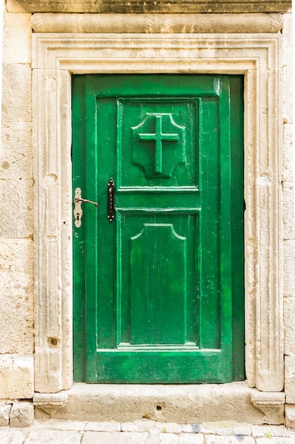 Foto vecchia porta verde in legno con croce cristiana a kotor montenegro