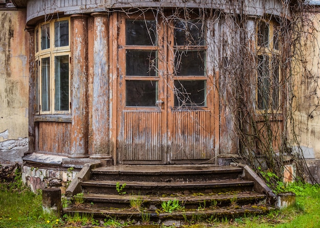 Foto vecchia porta di legno della casa di lerciume fuori