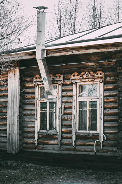 Фото Старый деревянный дом с окнами и дымоходом