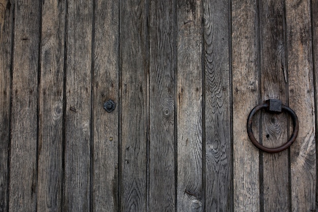 Old wooden rural door with metal ring handle