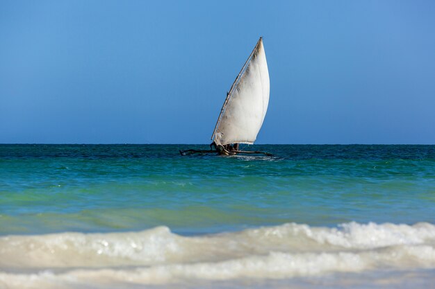古い木製の帆船アフリカ人がインド洋の波の上を滑空し、