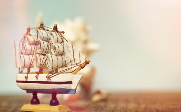 Photo old wooden ship with sails and masts toy on a stand. vintage and retro toys