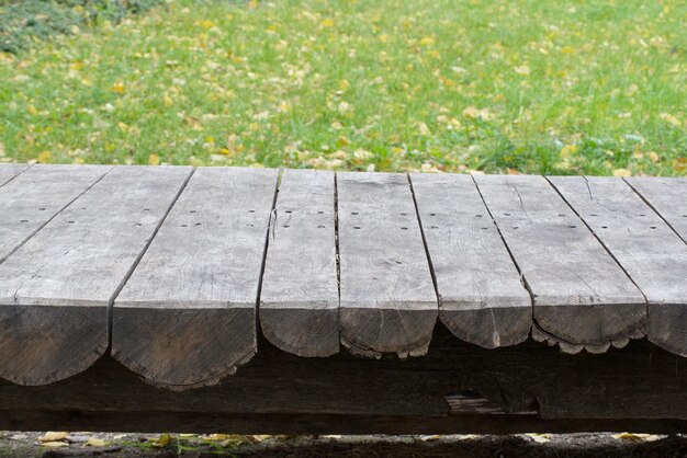 Old wooden table on green grass background