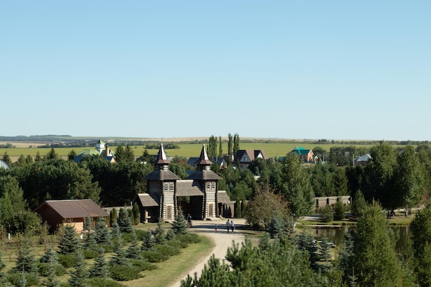 Old wooden village in forest landscape Park with tourists