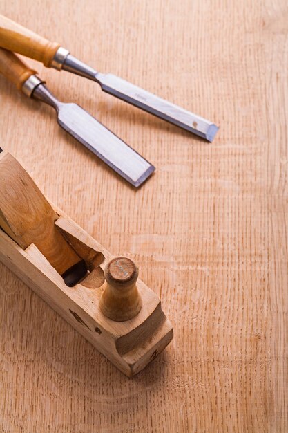 Old woodworkers plane and carpentry chisel on wooden board