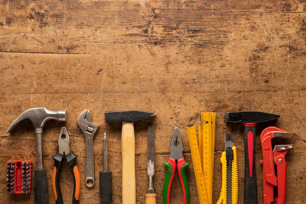 Old work hand tools on a vintage wooden background