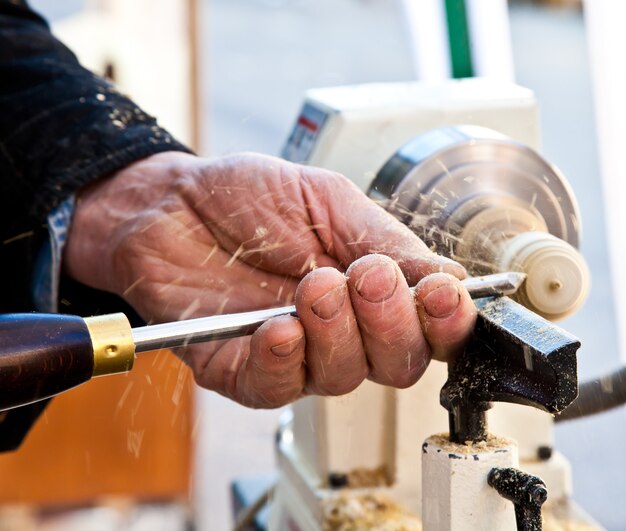 Old worker hands at lathe