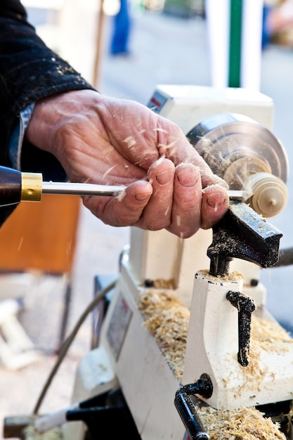 Old worker hands at lathe