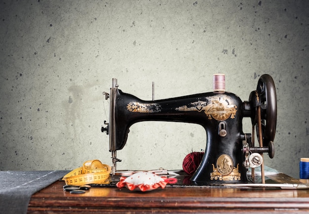 Old working hands at sewing machine on desk