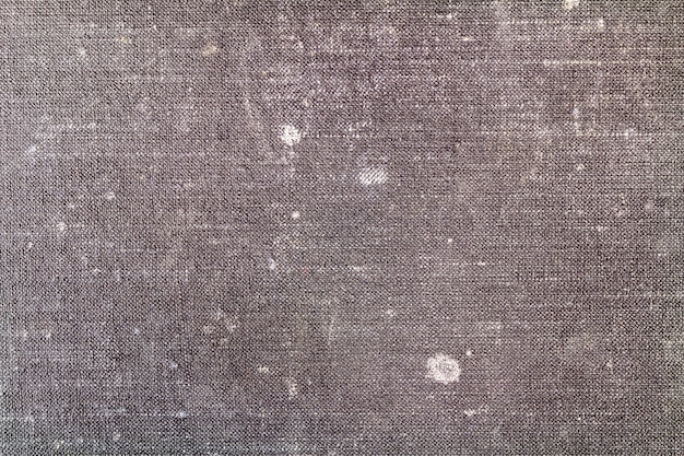 Old worn black textile texture with white spots. Abstract background