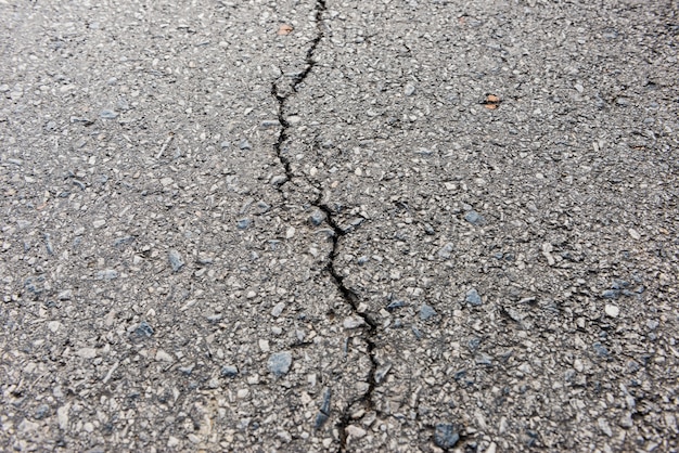 Old worn and cracked asphalt with cracks