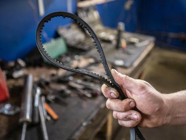 Old worn rubber alternator belt in men's hands The concept of car maintenance Copy space