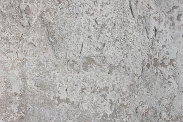 Old worn stone surface with cracks Closeup texture of cracked concrete Vintage grey background Ornamental stony surface