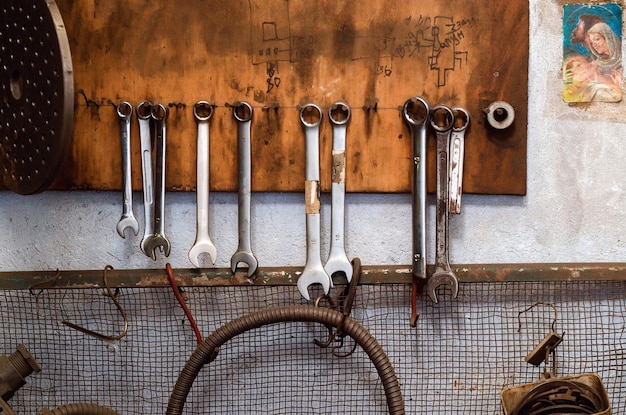 Old wrenches hang on the wall in the old workshop The atmosphere of the old garage