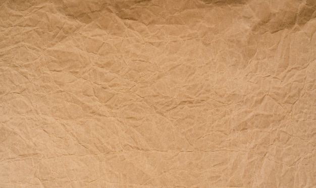 Old wrinkled brown paper texture . Rough brown kraft paper texture. Recycle cardboard sheet. Rustic  pattern design. Closeup crumpled paper bag. Grunge and creased parchment.