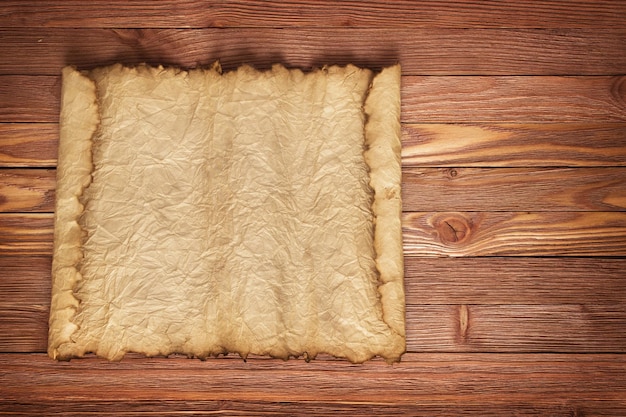 Old wrinkled paper with boards in the background