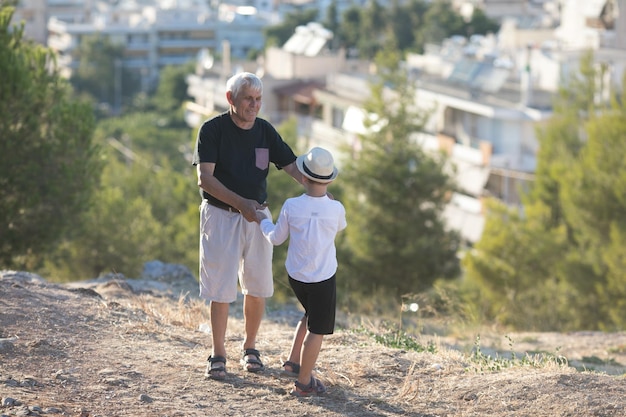 Vecchi e giovani concetto di generazione e relazioni familiari nonno e nipote in pensione che giocano con la giornata di sole godendosi all'aperto