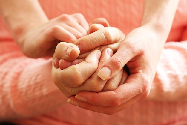 Photo old and young holding hands closeup