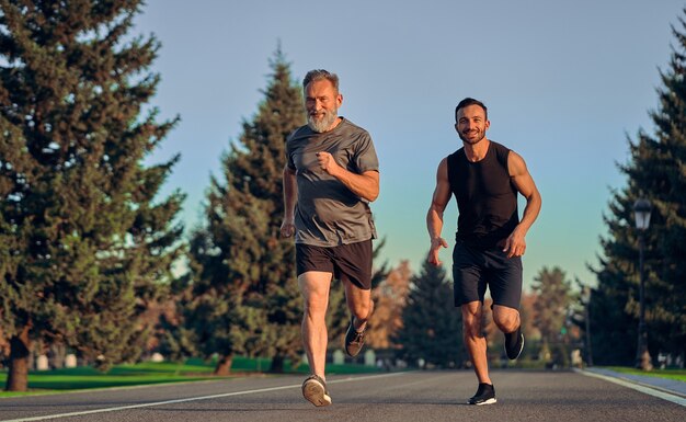 The old and young sportsmen running on the road