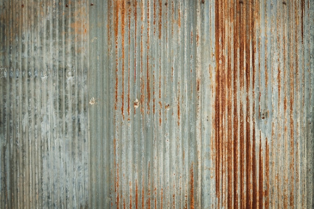 Старая предпосылка текстуры стены цинка, ржавая на гальванизированном защитном покрытии панели металла.