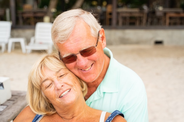 Older couple sit together at the beach.