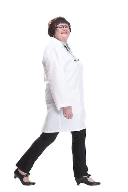 Older female doctor with a stethoscope walks forward