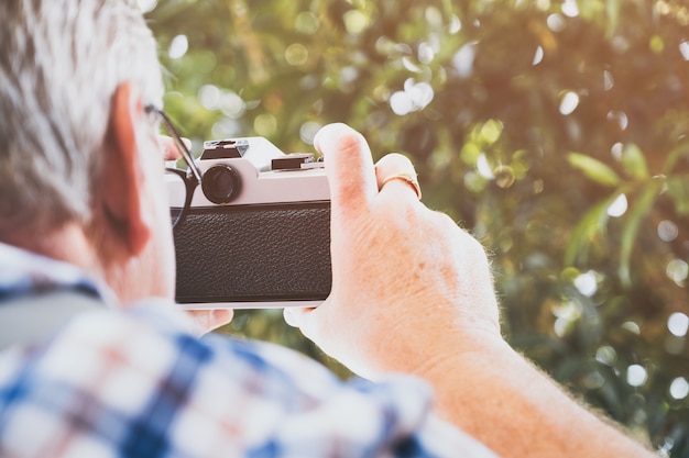 older hipster man with a old vintage camera